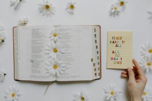 an open bible with flowers and a notepad