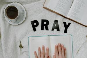 a person with a journal and a bible