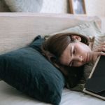 a woman hugging a picture frame while lying down on a bed